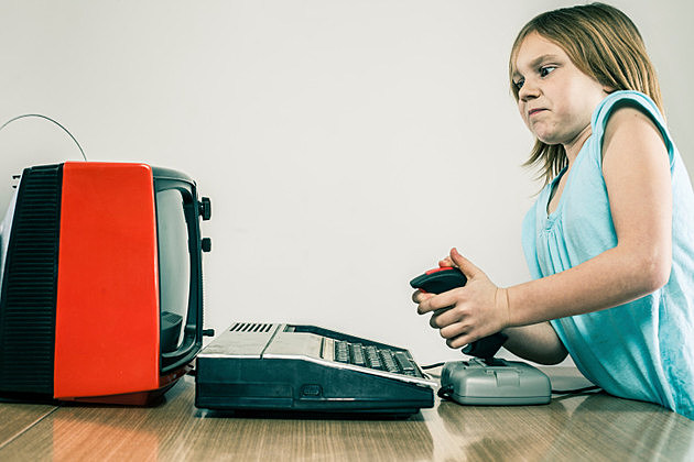 Little girl playing vintage video games with difficulty